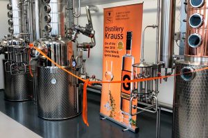 Brennkessel der Distillery Krauss mit orangem Band verbunden am Tag der offiziellen Eröffnung.