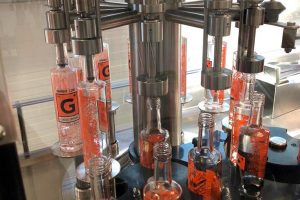 Foto aus der Abfüllung der Distillery Krauss. Man sieht wie die Flaschen in der Füllanlage gefüllt werden.