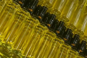 mehrere schlanke unetikettierte Flaschen mit gelbem Inhalt.