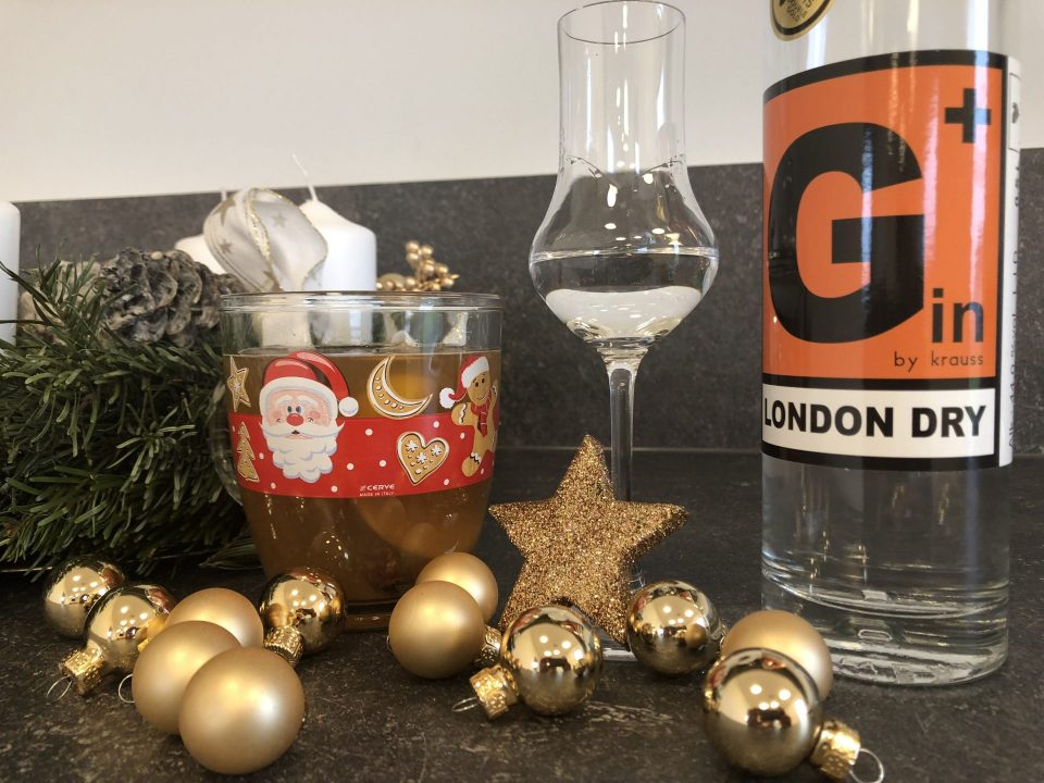 Adventkranz, goldene Weihnachtsdekoration, Glühgin in Tasse, Verkostglas mit Gin und eine Flasche G Plus Krauss Gin